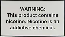 A nicotine warning statement for vaping products sold in the US. It graphic states: WARNING: This product contains nicotine. Nicotine is an addictive chemical.