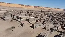 Some modern housing visible in the foreground with many other abandoned buildings of historical importance at the UNESCO World Heritage Site of Tichit in Tagant region of Mauritania.