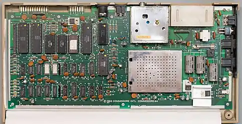 1980s Commodore 64 main board.  Most of the "orange" round disc parts are decoupling capacitors.