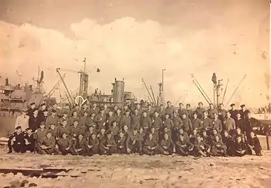  1071st Engineer Port Repair Ship Crew, with the Junior N. Van Noy in the background.