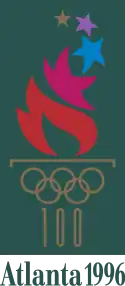 A fire, emitting many different-colored stars, burns from a cauldron represented by the gold-colored Olympic rings and the number "100" acting as the cauldron's stand. The words "Atlanta 1996", also written in gold, are placed underneath. The image is situated on a dark green background, with a gold border.