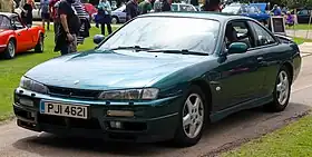 Front-three-quarter view of a two-door car with door mirrors, a sunroof, and a rear spoiler