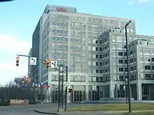 A boxy 10-story gray building with the Eli Lilly logo above the top floor.