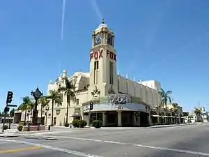 The Fox Theater from the corner of 20th St. and H St. Shows main entrance with neon marquee, and Spanish Revival clock tower.