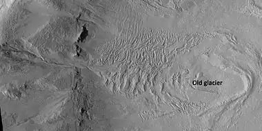 Glacier on a crater floor, as seen by HiRISE under HiWish program The cracks in the glacier may be crevasses.  There is also a gully system on the crater wall.