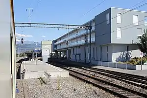 Boxy three-story building overlooking island platform