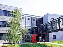 Front of and entrance to the Max Planck Institute for Gravitational Physics in Potsdam-Golm. A large red letter-E sculpture is next to the entrance.