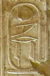 Inscription in raised hieroglyphs on a wall of light brown color