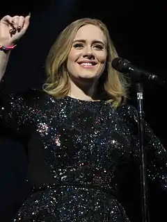 A woman wearing a black turtle neck with a microphone in front of her face