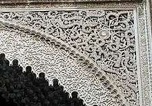 Arabesques carved in stucco over an archway in the al-Attarine Madrasa in Fes (14th century)