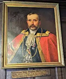 An oil painting of a white man with beard and moustache in mayoral robe and chain