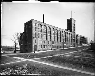 View of the Lafayette Avenue façade, looking east.  In this 1911 photo, the building has only its original three stories, making the mid-block tower twice as tall as the rest of the building.  Sidewalks and fire hydrants are installed, but the streets are still unpaved.