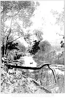 Black and white photograph of a river, with a man sitting in the foreground on a tree branch, and individuals boating in the background.