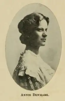 A young woman facing left of camera, with short hair wearing a white dress