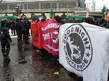 Blockade with three banners, one reading "Good night, white pride"