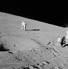 David Scott collecting samples from a boulder down the northeast slope from the rim of St. George