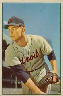 A man in a gray baseball uniform with blue under-sleeves and cap