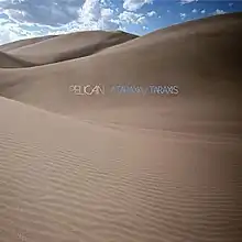 A photograph of sloping dunes in a desert overseen by a blue sky