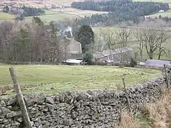 Stone farm buildings among green hills