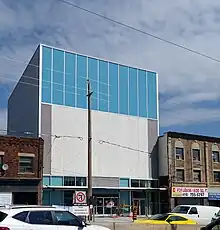 A photo of the largely completed secondary entrance to Avenue station. It is a modern, white building with glass panelling.