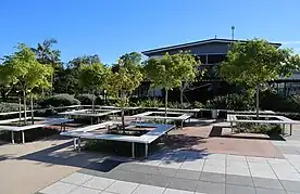 Seating grounds for students inside Aviation State High school, seating and tables are visible in a courtyard surrounded by garden beds and vegetation.