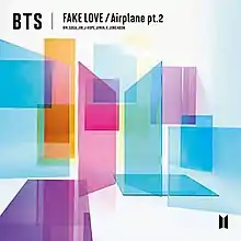 Cover of BTS' Fake Love / Airplane pt. 2 Japanese Single. The BTS logo, two trapezoids with the flat end facing each other, are in the middle, made out of pink (left) and blue (right) tinted glass. Various rectangles of tinted glass, in pink, purple, orange, and black, surround the logo. A black version of the logo is on the bottom right, and the worst "BTS Fake Love / Airplane pt. 2" is written at the top.