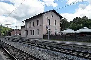 Two-story building with gabled roof on side platform