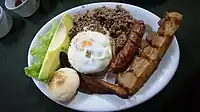 Bandeja paisa, a typical meal popular in Colombian cuisine. Includes red beans cooked with pork, white rice, ground meat, chicharon, fried egg, plantain, chorizo, arepa, hogao sauce, morcilla and avocado.