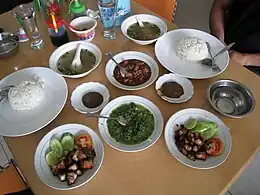 Batak daun ubi tumbuk (center) served with saksang and panggang, North Sumatra.