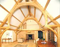 A bent in a finished timber frame home in the form of a hammerbeam truss.