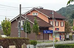 Two story salmon-colored building with adjoining freight house