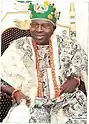  Oba Oladele Olashore is show in traditional Yoruba attire sitting on a chair