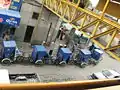 line of bicycle taxis waiting for business on Horacio Zuñiga Street just outside the Metro Los Reyes station