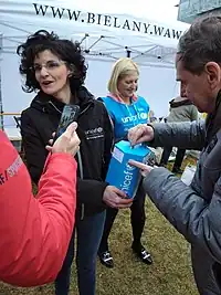 A woman handing a UN-blue colored box with a UNICEF label to a Ukrainian man