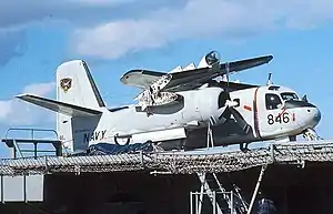 Colour photo of a military propeller aircraft with its wings folded