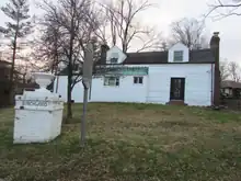 Birchwood - a white house log house with signs in front of it.