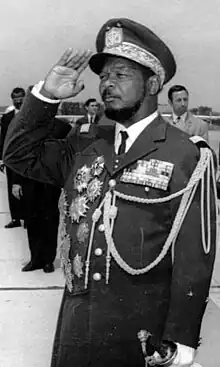 Jean-Bédel Bokassa stands saluting in military uniform