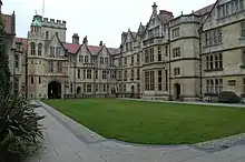 Courtyard of an early-modern sandstone building with a lawn at the centre.