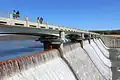 A view of the bridge and water flowing over the dam