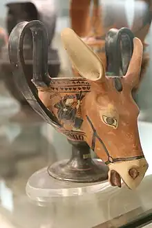 Photograph of a pottery drinking-cup in the shape of a donkey's head: the handles form the ears