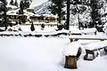 Snow-covered wooden cottages and benches