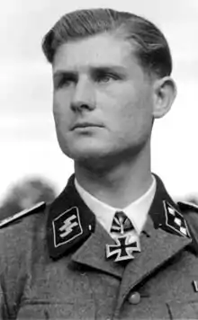 A man wearing a military uniform and a neck order in the shape of a cross.