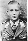 A man wearing a military uniform with an Iron Cross displayed at the front of his uniform collar.