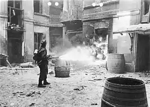 A German soldier sets fire to a building