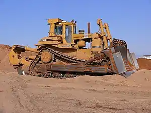 The Caterpillar D10N bulldozer evolved from tracked-type tractors and is characterized by a steel blade attached to the front that is used to push other equipment and construction materials, such as earth.