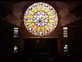 View of the 16-paneled stained glass window, created by Joël Mône and realized by Vitrail Saint-Georges, from the third level of church building.