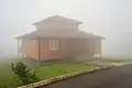 A mountain lodge is shrouded in thick fog in daytime