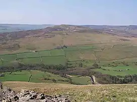 Skyline shot of a hilltop, with green fields below