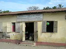 The outside of a beige building with children visible inside the open door