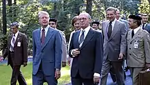 Carter, Begin, and Brzezinski walking together outside.